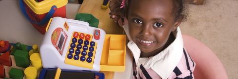 Young African-American girl with toy cash register