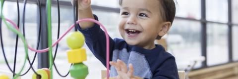 Toddler boy playing with game.