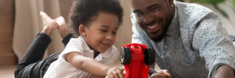 First Years 2022 b hi res Father and son playing with car.