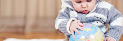 Child Care Mapping Baby explores a globe.