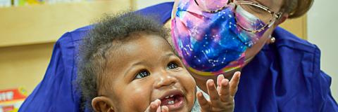 LOCATE Child Care 3 Happy baby with child care provider.