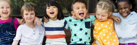 Our Team Diverse preschoolers happily sitting together.
