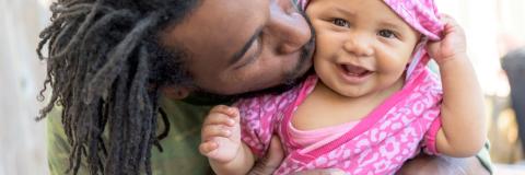 Dad kissing baby daughter, 