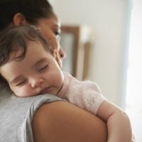 Baby sleeping on her mother's shoulder. 