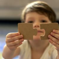 Young child with jigsaw puzzle pieces. 