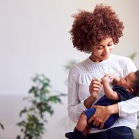 Mom smiling at infant in her arms. 