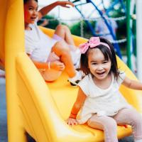 Preschool children on a yellow slide 