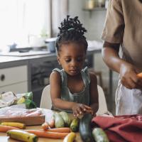 Preschool child helping mom make a healthy dinner. 