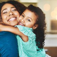 Mom and daughter hug and smile. 