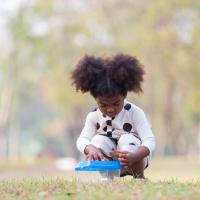 Little girl doing a STEM experiment in the park.