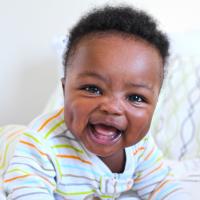 Smiling baby boy in stripped pajamas.