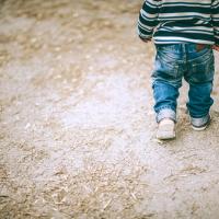 Toddler walking by himself.