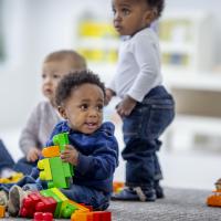 Toddlers playing with big legos. 