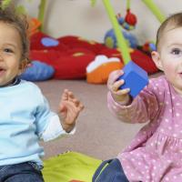 Two babies enjoying themselves playing music. 
