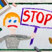 Colorful drawing: Sad boy holding a STOP sign in his hand 