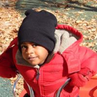 Young boy bundled up on bicycle 