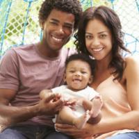 family with baby relaxing on outdoor garden swing seat 