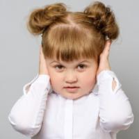 Disappointed little girl covering her ears isolated 