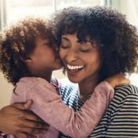 Shot of an adorable little boy kissing his mother on the cheek while bonding together at home 