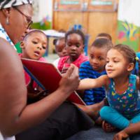 Teacher reading a book with a class of preschool children 