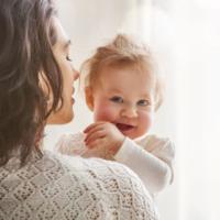 Smiling baby in mother's arms 