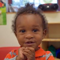 Smiling little girl with clenched hands 