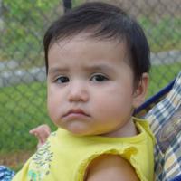 somber looking baby sitting in a stroller 