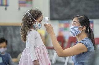 Child care provider taking a child's temperature.