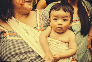 Babies and climate change. Baby in a sling with mom in Amazonia.