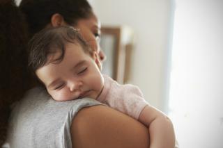 Baby sleeping on her mother's shoulder. 