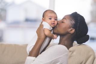 RFP for Family Support Mom kissing her baby's cheeks.