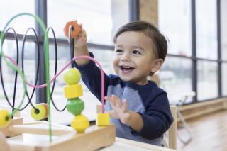 Toddler boy playing with game.