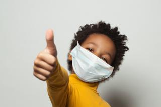 Masking for Miunchkins Thumbs up from a masked young child.