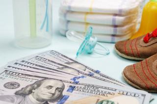 Billionaires for babies. One hundred dollar bills, diapers, bottle and pacifier.
