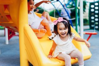 Preschool children on a yellow slide 