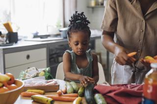 Hunger and Abuse Preschool child helping mom make a healthy dinner.