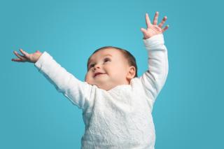 Happy baby with light blue background.