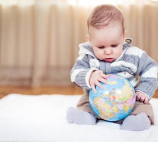 Child Care Mapping Baby explores a globe.