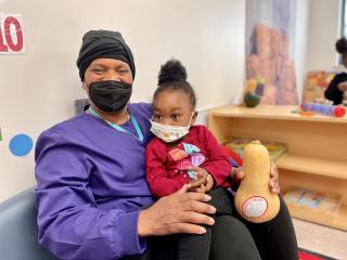 FSC caregiver with a baby and a squash.