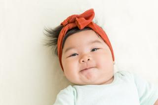 Baby is Watching You Baby looking at camera and smiling.