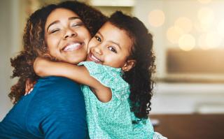 Mom and daughter hug and smile. 