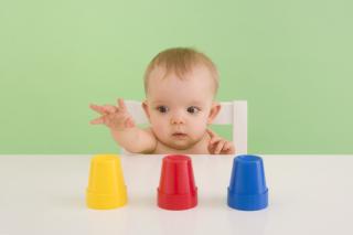 Baby making decision between three cups. 