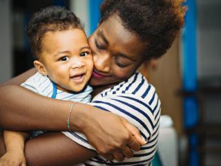 Child Care Transitions Adult hugging a happy toddler.