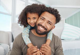 Father and his little daughter relaxing together at home .