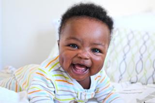 Smiling baby boy in stripped pajamas.