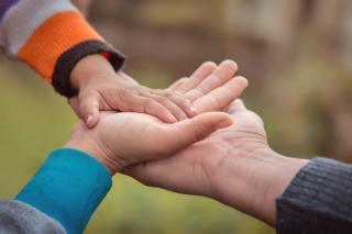 Stacked hands - father, mother, baby.