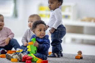 Toddlers playing with big legos. 