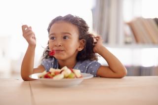 Healthy Foods Leads to Healthy Kids Little girl eating a fresh fruit salad.