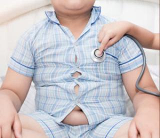 Little hand doctor checks heart of obese toddler boy with stethoscope, healthcare concept