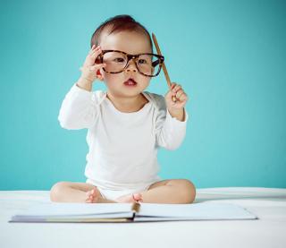 Infant wearing Dad's glasses